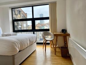 a bedroom with a bed and a chair and a window at Second Nest London Warehouse in London