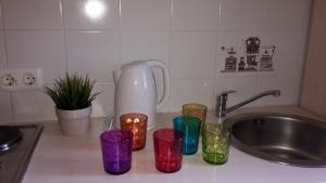 a kitchen counter with a mixer and four colorful cups at Apartments Henc in Novigrad Istria