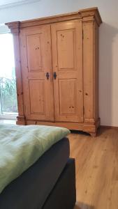 een slaapkamer met een houten kast en een bed bij Bergjuwel Kleinwalsertal in Hirschegg