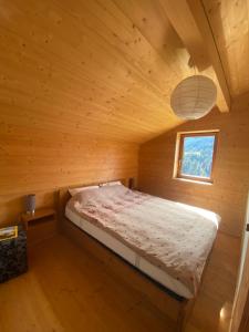 a bed in a wooden cabin with a window at Chalet Villars-Gryon 8pax Cosy in Gryon