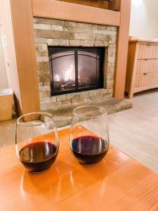 two glasses of wine sitting on a table in front of a fireplace at Suncadia Lodge Studio Unit in Cle Elum