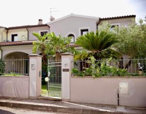 a white house with a gate and trees at Casa Sterlizia [Olbia] in Olbia