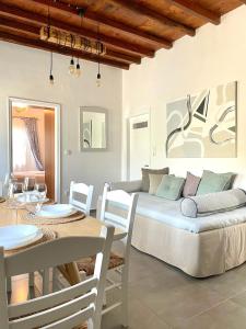 Lemon houses - Faros, Sifnos في فاروس: غرفة معيشة مع سرير وطاولة وكراسي