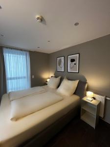 a bedroom with a large bed with two pillows at mala me Hotel in Hannover