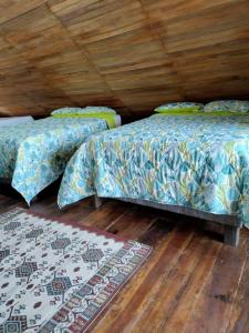 2 Betten in einem Zimmer mit Holzdecke in der Unterkunft Hotel Calamari Baru in Playa Blanca