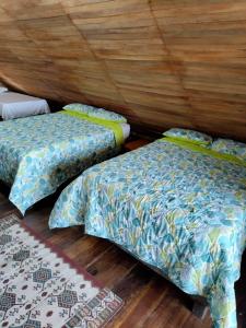 a room with two beds and a wooden floor at Hotel Calamari Baru in Playa Blanca