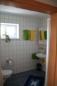 La salle de bains est pourvue d'un lavabo, de toilettes et d'une fenêtre. dans l'établissement Ferienwohnung Kalin, à Neualbenreuth