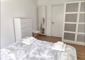 - une chambre blanche avec un lit et 2 serviettes dans l'établissement Apartamento Casa Davila, à Santander
