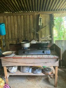 a stove with two pots and pans on top of it at La Muñequita Lodge 1 - culture & nature experience in Palmar Norte