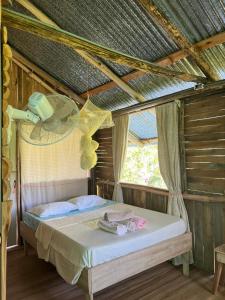a bedroom with a bed with a phone on the ceiling at La Muñequita Lodge 1 - culture & nature experience in Palmar Norte
