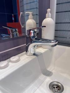 - un lavabo avec un robinet et 2 bouteilles de savon dans l'établissement Apartment In The Old Town - Stare Miasto , Wi-Fi - by HIK Apartments, à Varsovie