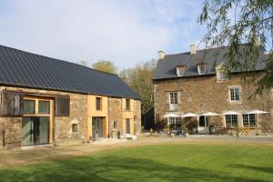 un gran edificio de ladrillo con un patio delante en Le Manoir des Haies SPA en Les Champs-Géraux