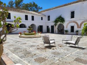 einen Innenhof mit zwei Stühlen und einem Brunnen in der Unterkunft Hacienda Las Lumbreras Casa Rural con Piscina in Montellano