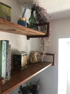 a shelf with flowers and a vase on it at 10 da Muralha in Estremoz