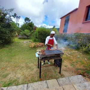 un hombre cocinando comida en una parrilla en un patio en Vallombre natiora, 