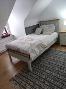 a bedroom with a bed and a rug on a floor at Ferguson's Traditional Townhouse in Dunkineely