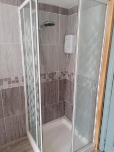 a shower with a glass door in a bathroom at Ferguson's Traditional Townhouse in Dunkineely