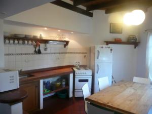 a kitchen with a table and a white refrigerator at E Luru in Mar de las Pampas