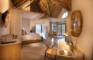 a bedroom with a bed and a living room at Serondella Game Lodge in Thornybush Game Reserve