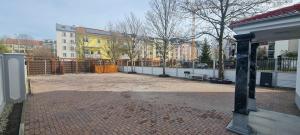 un aparcamiento de ladrillo con una valla y edificios en KL Apartments, en Leipzig