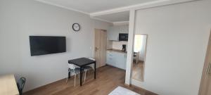 Habitación con cocina, mesa y taburete en KL Apartments, en Leipzig