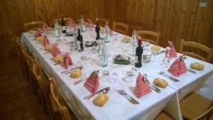un lungo tavolo con una tovaglia bianca e bottiglie di vino di Antico Albergo Sant'Antonio a Fonzaso
