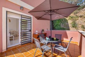 貝納加爾彭塔的住宿－Niña Sureña Home Añoreta Golf，庭院配有桌椅和遮阳伞。