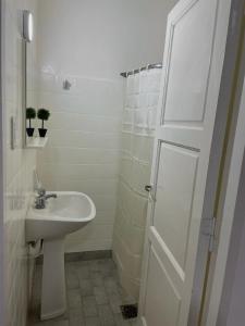 uma casa de banho branca com um lavatório e um chuveiro em El Rosario em Pocito