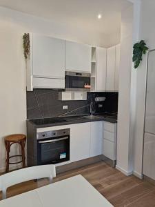 a kitchen with white cabinets and a stove top oven at Lucania25 in Milan