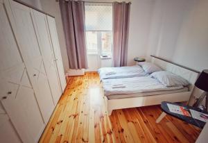 - une petite chambre avec un lit et une fenêtre dans l'établissement Apartament Tuwim, à Przemyśl