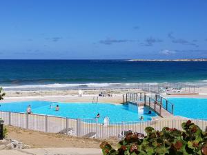 una piscina junto al océano con gente en ella en Orient Bay Beach Studio, en Orient Bay