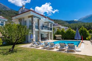 a villa with a swimming pool and chairs at Yaşam Park Rena Villaları Ölüdeniz in Fethiye