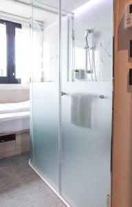 una doccia in vetro in un bagno con lavandino di Royal Jade Boutique Hotel a Taipei