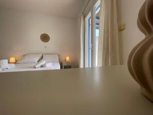 a room with a bed and a table with a window at Villa Maniati Studios in ayios Petros