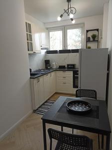 a small kitchen with a table and a refrigerator at Zaciszny Apartament Old Town Gdansk in Gdańsk