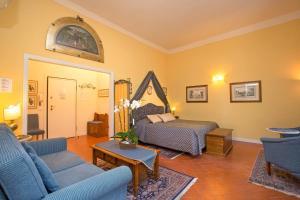 a living room with a couch and a bed at La Casa Del Garbo - Luxury Rooms & Suite in Florence