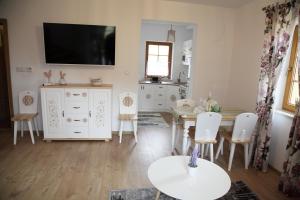 a living room with a table and a tv on the wall at Beskidzka Chałupa in Milówka