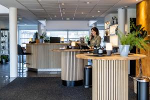 a woman talking on a cell phone in an office lobby at The Lodge Billund in Billund +143 photos