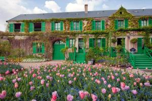 een groen huis met bloemen ervoor bij Les Bouches Manon in Pressagny l'Orgueilleux