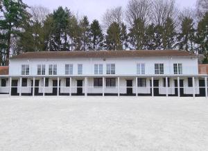 duży biały dom z mnóstwem okien w obiekcie Royal Horses w mieście Overijse