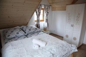 a bedroom with a bed with two towels on it at Beskidzka Chałupa in Milówka