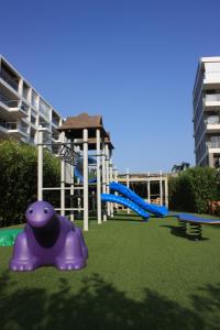 un parque infantil con un juguete púrpura en la hierba en Apartaestudio acceso al mar, en Cartagena de Indias