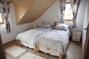 um quarto com uma cama branca num sótão em Beskidzka Chałupa em Milówka