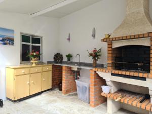 a kitchen with a brick fireplace and a counter top at Casa Maria da Eira in Arcos de Valdevez