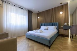 a bedroom with a blue bed and a table and chairs at Syncron Centre Skyline Rooftop Tirana Apartments in Tirana