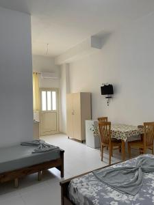 a room with two beds and a table and chairs at Vila Melisa in Durrës