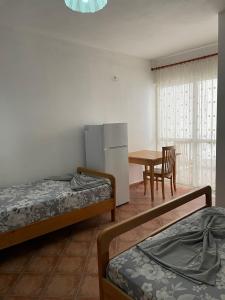 a room with three beds and a table and a refrigerator at Vila Melisa in Durrës