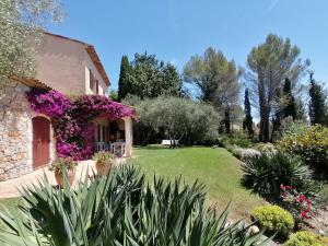 un giardino di fronte a una casa con fiori viola di LA PERASCEDA a Spéracèdes