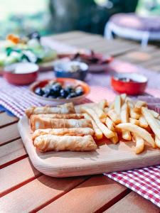 Loca Sapanca Bungalov في صبنجة: طاولة خشبية مع صحن طعام وبطاطس مقلية