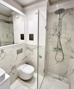 y baño con ducha, aseo y lavamanos. en LUMI Apartament Mokotów, en Varsovia